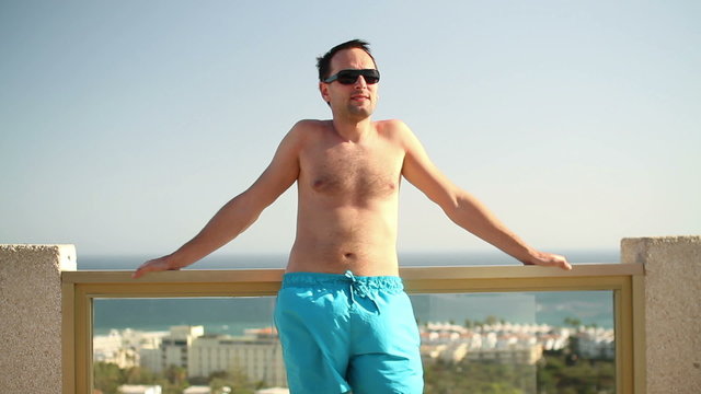 Portrait of young man sunbathing on luxury hotel terrace