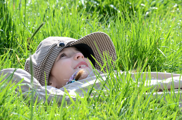 Kind in der Wiese blickt nach oben