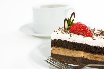 Piece of chocolate cake with strawberry decorate on top and cup