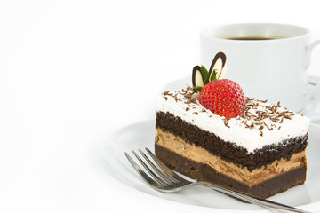 Piece of chocolate cake with strawberry decorate on top and cup