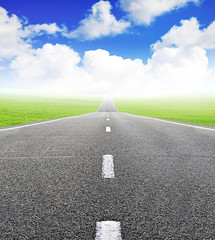 green field and road over blue sky