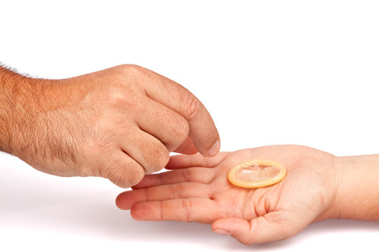 Male hand taking a condom from a female hand