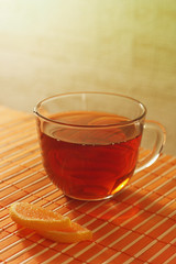Cup of tea and fruit jelly on a bamboo table cloth still life
