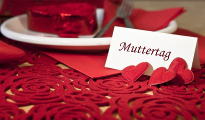 Symbolbild Muttertag - Grusskarte zum Muttertag in rot - Herzchen dekoriert auf einem Tisch mit einem kleinen Schild