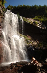 Young sexy beautiful girl stands at nature waterfall location
