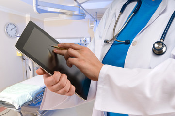 Doctor pointing on tablet PC at emergency room
