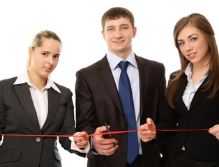 Business people cutting a red ribbon with a pair of scissors