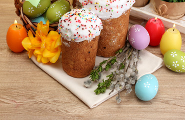 Beautiful Easter cakes, colorful eggs in basket and candles
