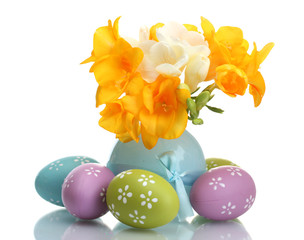 Beautiful yellow freesias in vase and Easter eggs isolated