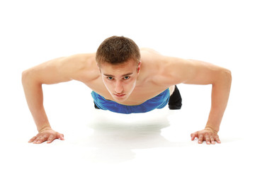 A handsome young man dressed in blue shirt making push-ups