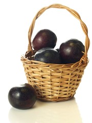 Plums in wicker, isolated