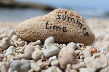 Fototapeta na wymiar Czas letni - Wpisany na skale na plaży