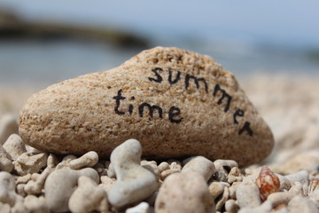 Fototapeta na wymiar Czas letni - Wpisany na skale na plaży