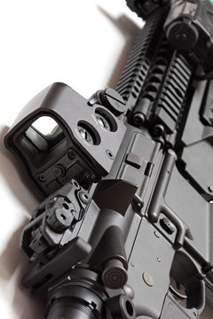 Modern tactical laser sght on assault carbine close-up.