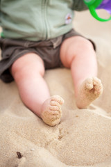 Baby feet covered in beach sand