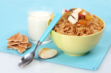 tasty cornflakes in bowl with dried fruits and glass of milk