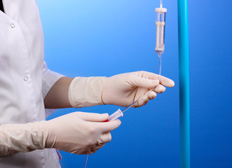 Nurse doing infusion on blue background