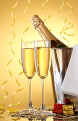Champagne bottle in bucket with ice and glasses of champagne,