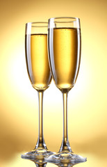 glasses of champagne on yellow background