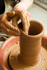 hands of a potter, creating an earthen jar on the circle