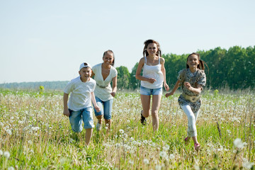 women with teens running in grass