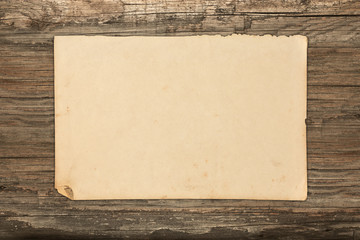 Aged paper sheet on a wooden background