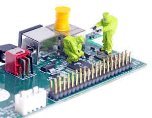 tiny chemical team in hazmat suits examining integrated circuit