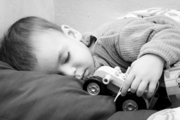 Chłopiec śpiący z traktorem - obrazy, fototapety, plakaty