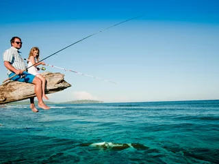 Poster Vissersteam - klein meisje vissen met vader op het strand © Gorilla