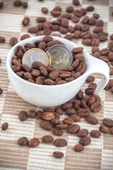 Ceramic cup with coffee seed and euro coins