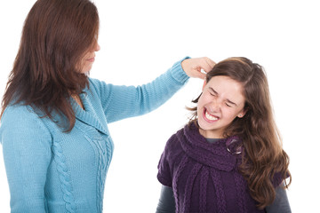 mother pulling her daughter's ear and punishing her