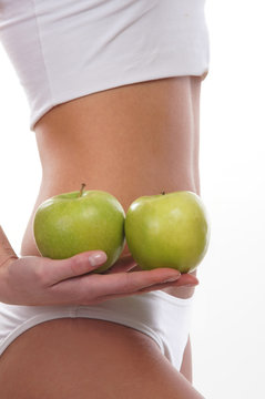 Sexy body of a young woman holding fresh apples