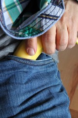 hand zieht westernmäßig Banane aus jeans duell