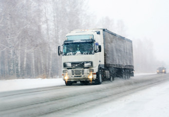 Fototapeta na wymiar ciężarówka jedzie na drodze zimą