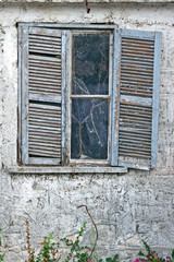 Okno z okiennicą w zrujnowanym domu, Grecja