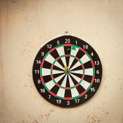 Dartboard hanging on an old, shabby wall (image with copy space)