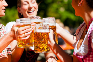 Zwei glückliche Paare sitzen im Biergarten