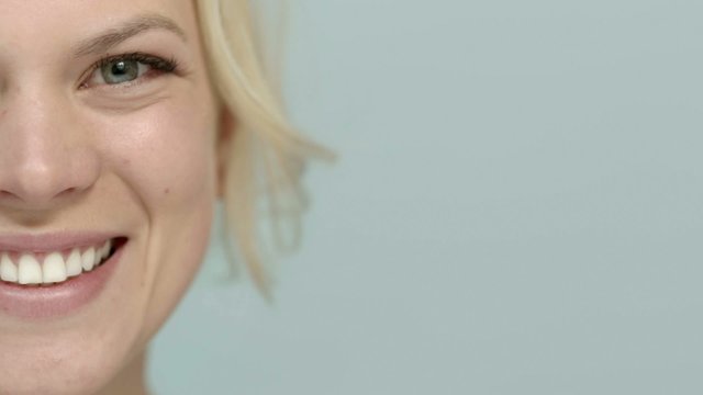 Young beautiful female teen smiling at camera, cropped view