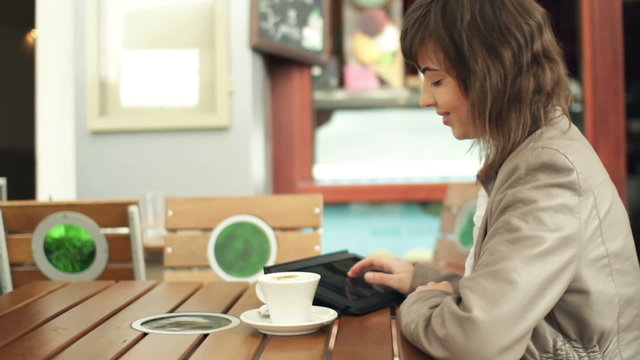 Woman with tablet computer in cafe, steadicam shot