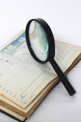 Fototapeta premium Magnifying glass and notebook
