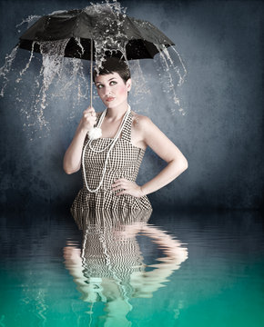 Pin-up girl with umbrella under water splash with river reflecti