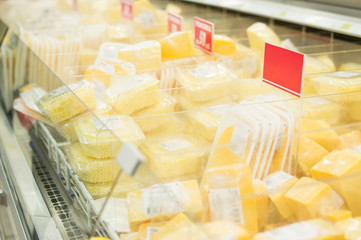 Variety of cheese pieces in supermarket