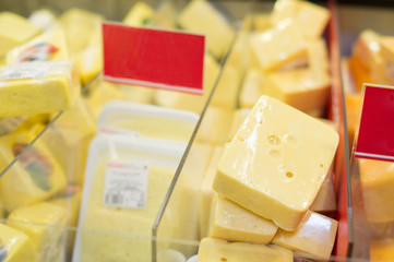 Variety of cheese pieces in supermarket
