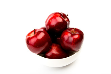 Red apple on white plate isolated on white background