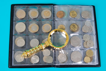 Magnifying glass and album with a collection of coins
