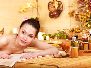 Woman getting massage in bamboo spa.