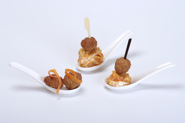 aperitivo in cucchiaio di ceramica su fondo bianco