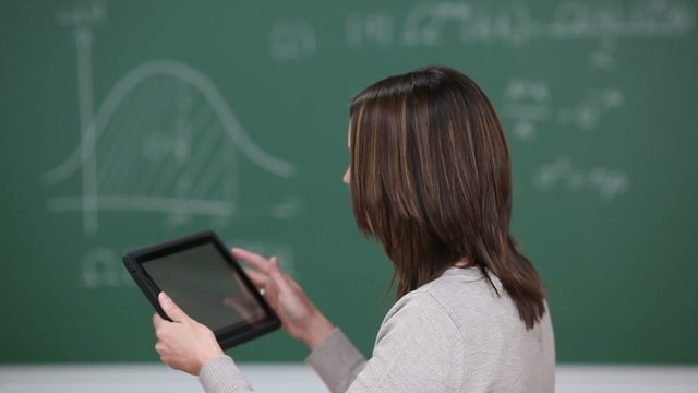frau mit tablet-computer vor der tafel