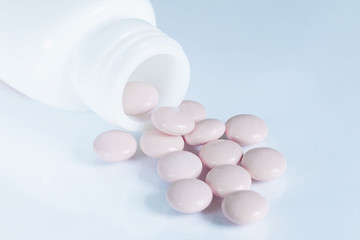 Pot of pink tablets and their bottle