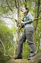 woman in tree using binoculars